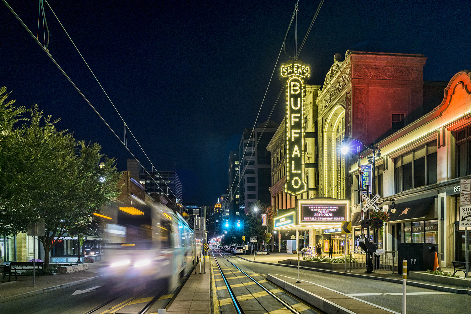 Lights from a passing streetcar pass in front of the Shea's Performing Arts Center in downtown Buffalo